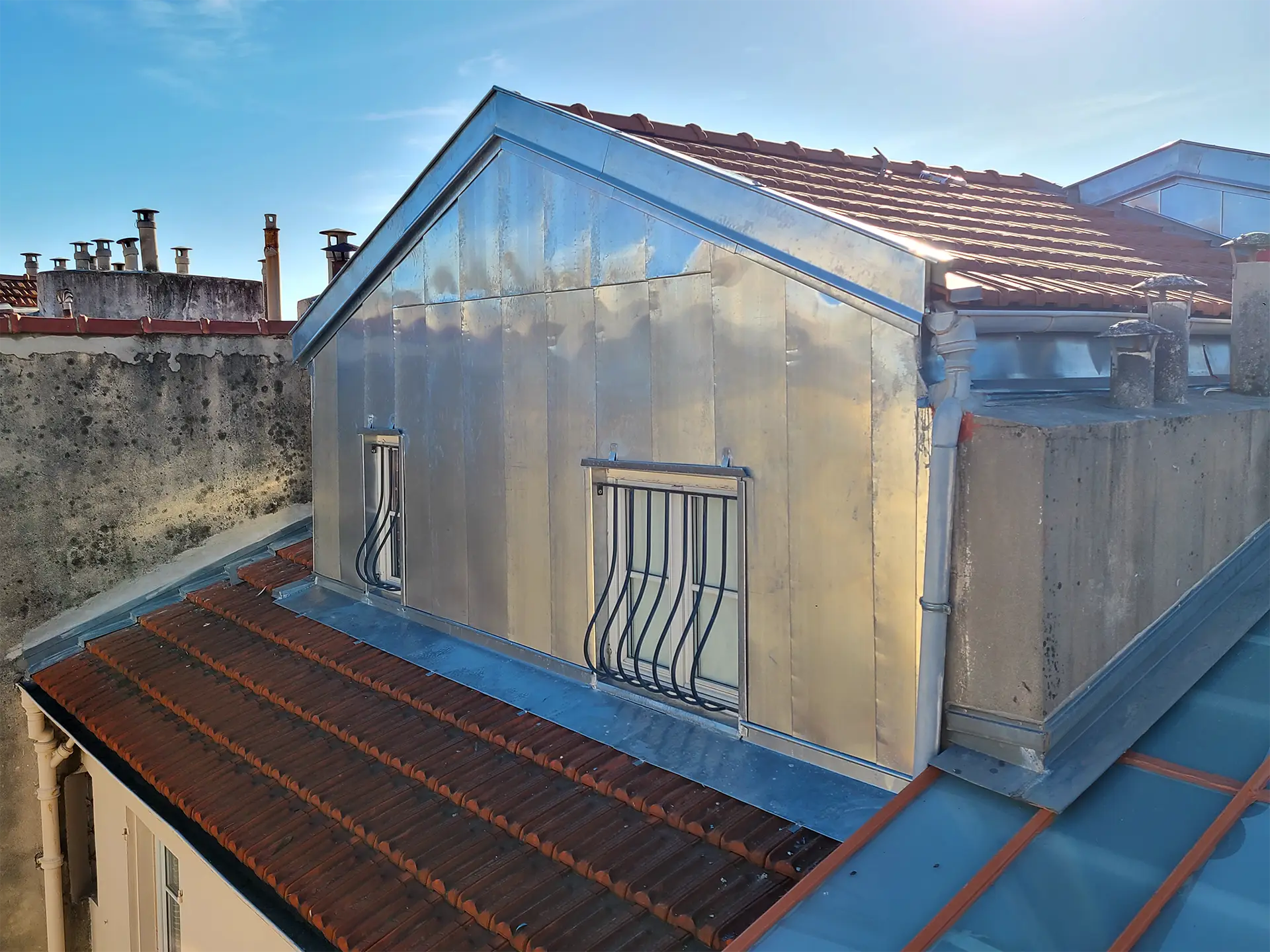 Rénovation d'un chien assis et d'un bardage en zinc à Nice par un couvreur zingueur