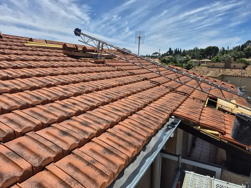 Couverture en tuiles de Marseille presque achevée, monte-tuiles encore appuyé sur le versant