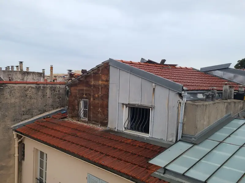 Lucarne avant rénovation à Nice, une face entièrement corrodée et l'autre en zinc fatigué