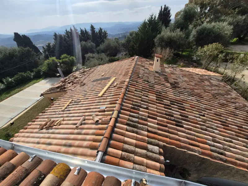 Toiture recouverte de ses tuiles anciennes patinées, gouttière neuve posée à l'égout