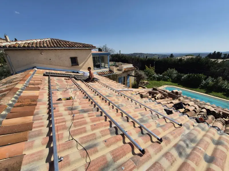 Rails de fixation neufs du photovoltaïque posés sur la couverture rénovée, piscine en contrebas