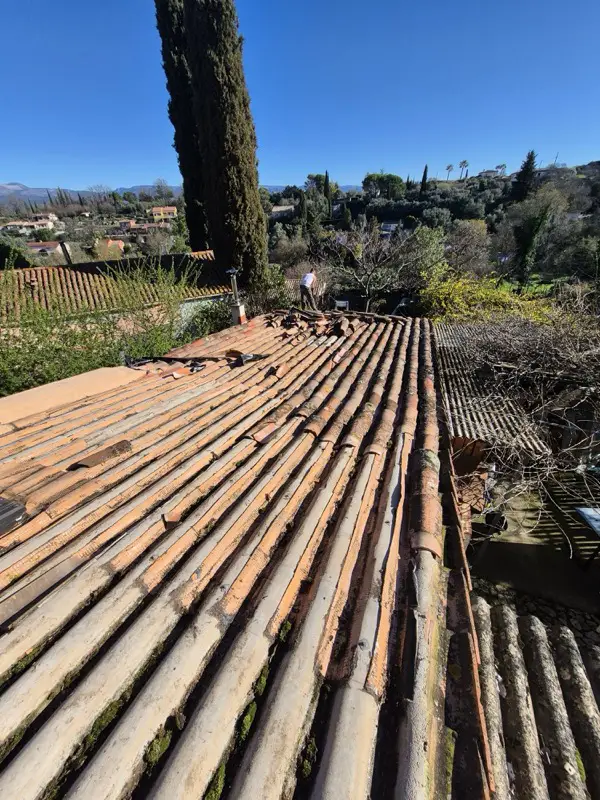 Ancienne couverture usée et moussue d'une maison de Saint-Paul-en-Forêt, dépose entamée au faîtage
