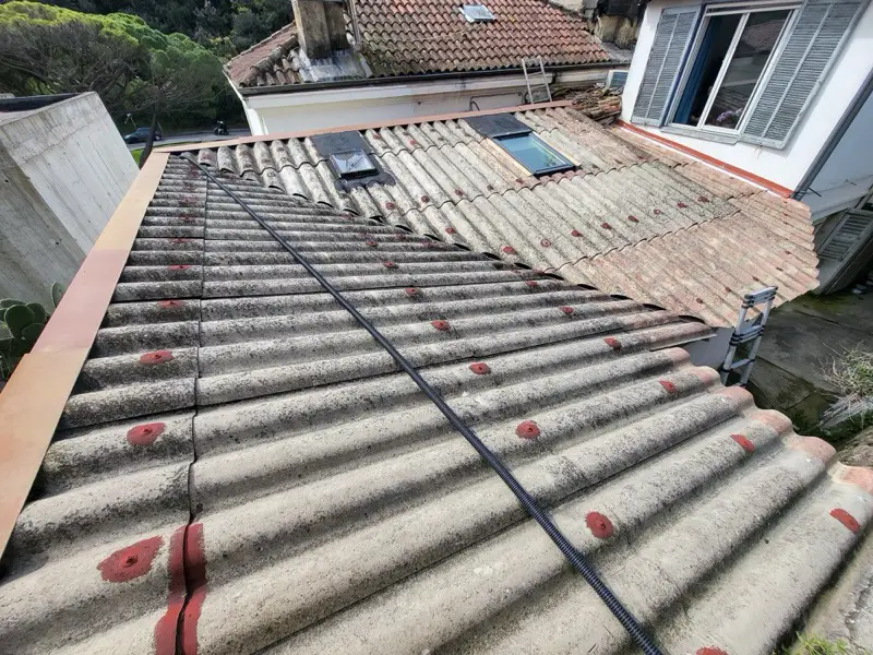 Toiture en plaques ondulées vieillissantes avant rénovation à Vallauris, fixations reprises une à une au mastic