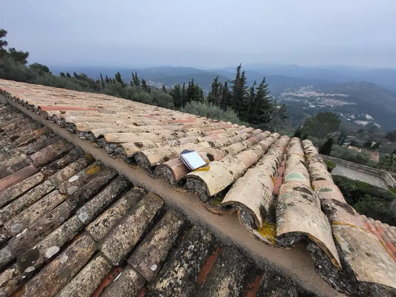 Rangs de tuiles qui ondulent sur l'ancienne toiture, signe d'une charpente fatiguée