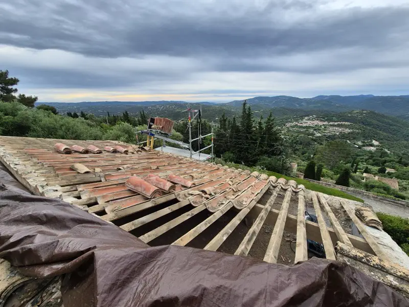 Dépose de la couverture en cours, tuiles anciennes triées en piles pour le réemploi