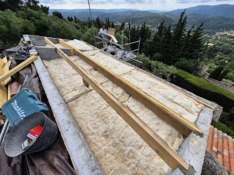 Poutres neuves posées et laine de verre de 30 cm installée entre les appuis, à ciel ouvert