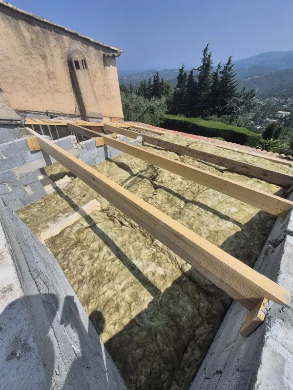 Structure neuve en bois posée sur des maçonneries reprises en parpaings, isolant en place