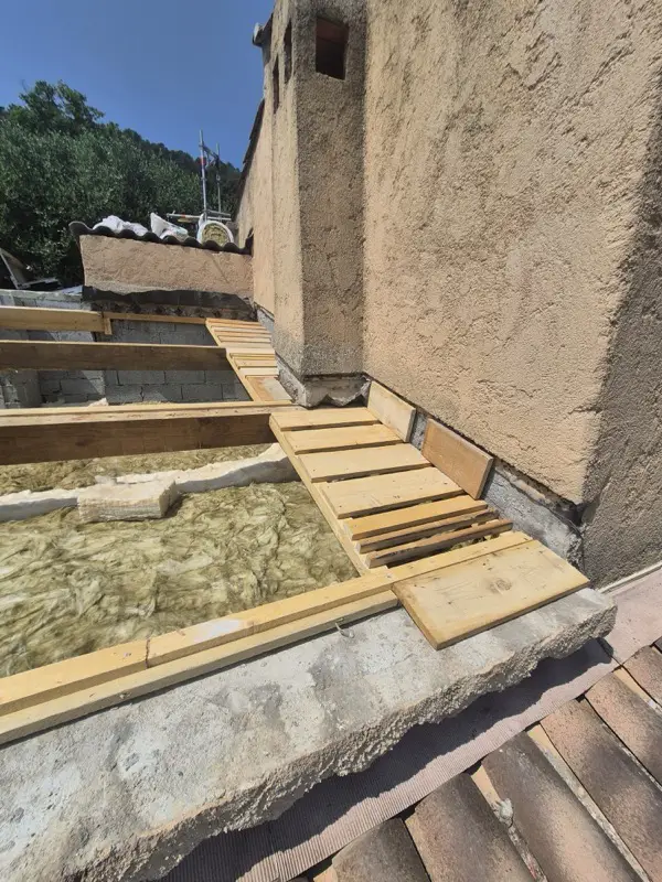 Voligeage en bois neuf ajusté à la jonction du toit et des murs, prêt à recevoir la zinguerie