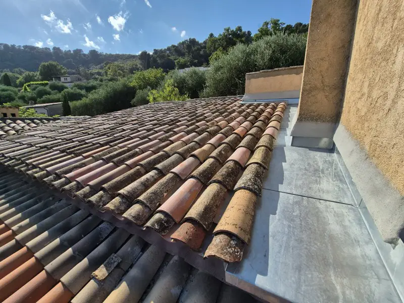Couloir en zinc et solin façonnés sur mesure contre le mur, tuiles anciennes autour