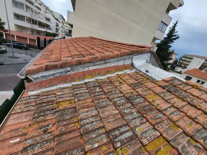 Toiture en tuiles canal envahie de lichens avant rénovation à Fréjus, bande de mortier fissurée